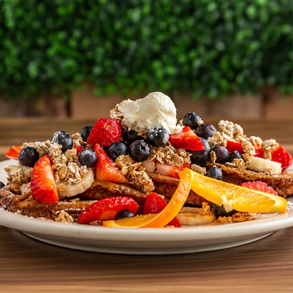 Buttermilk Eatery's breakfast waffles topped with berries, bananas, granola, and whipped cream.