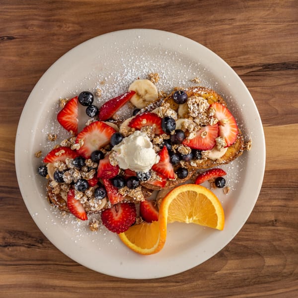 Buttermilk Eatery's French toast topped with strawberries, blueberries, bananas, granola, and whipped cream.