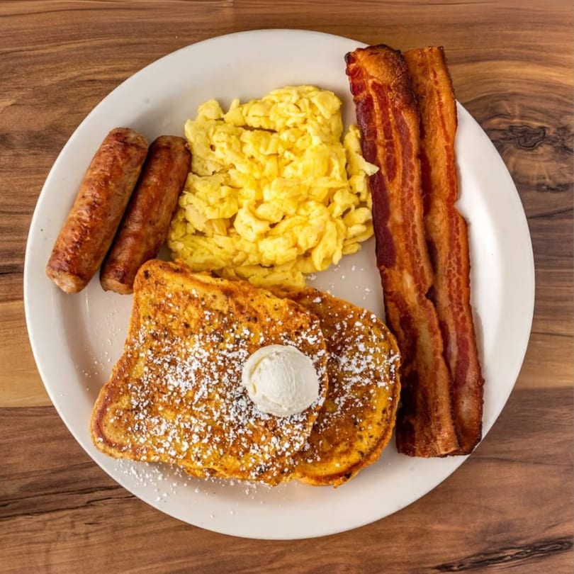 Buttermilk Eatery's breakfast plate with French toast, bacon, scrambled eggs, and sausage links.